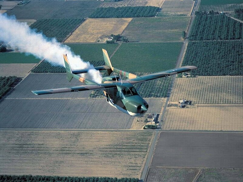 Military aircraft flying over farmland