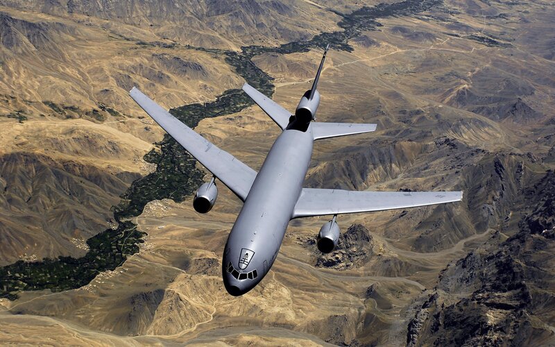 Military aircraft flying over mountains