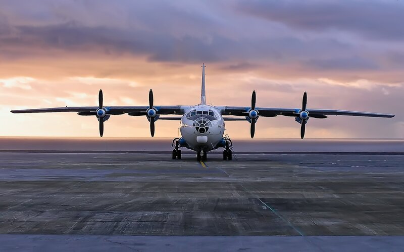 Military aircraft on tarmac at sunset