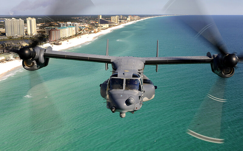 military aircraft over coastal city