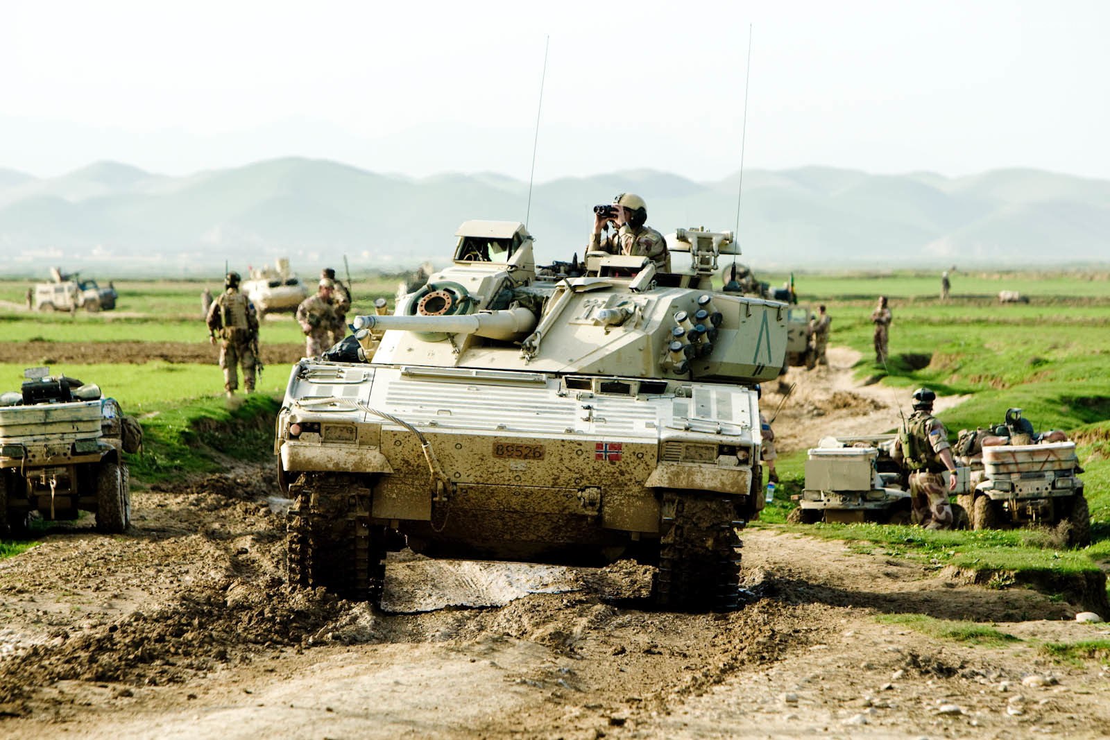 Military convoy in muddy field
