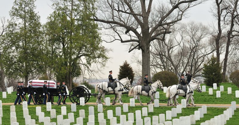 Military funeral procession at a cemetery