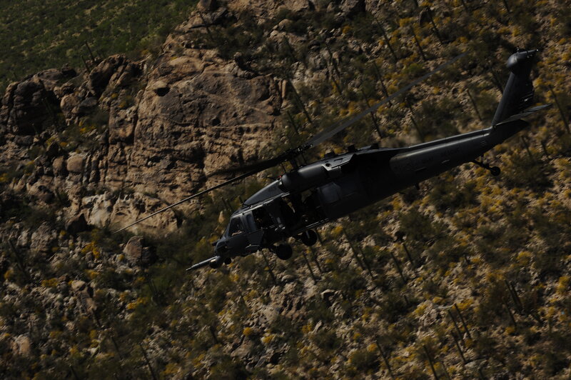 Military helicopter flying over canyon