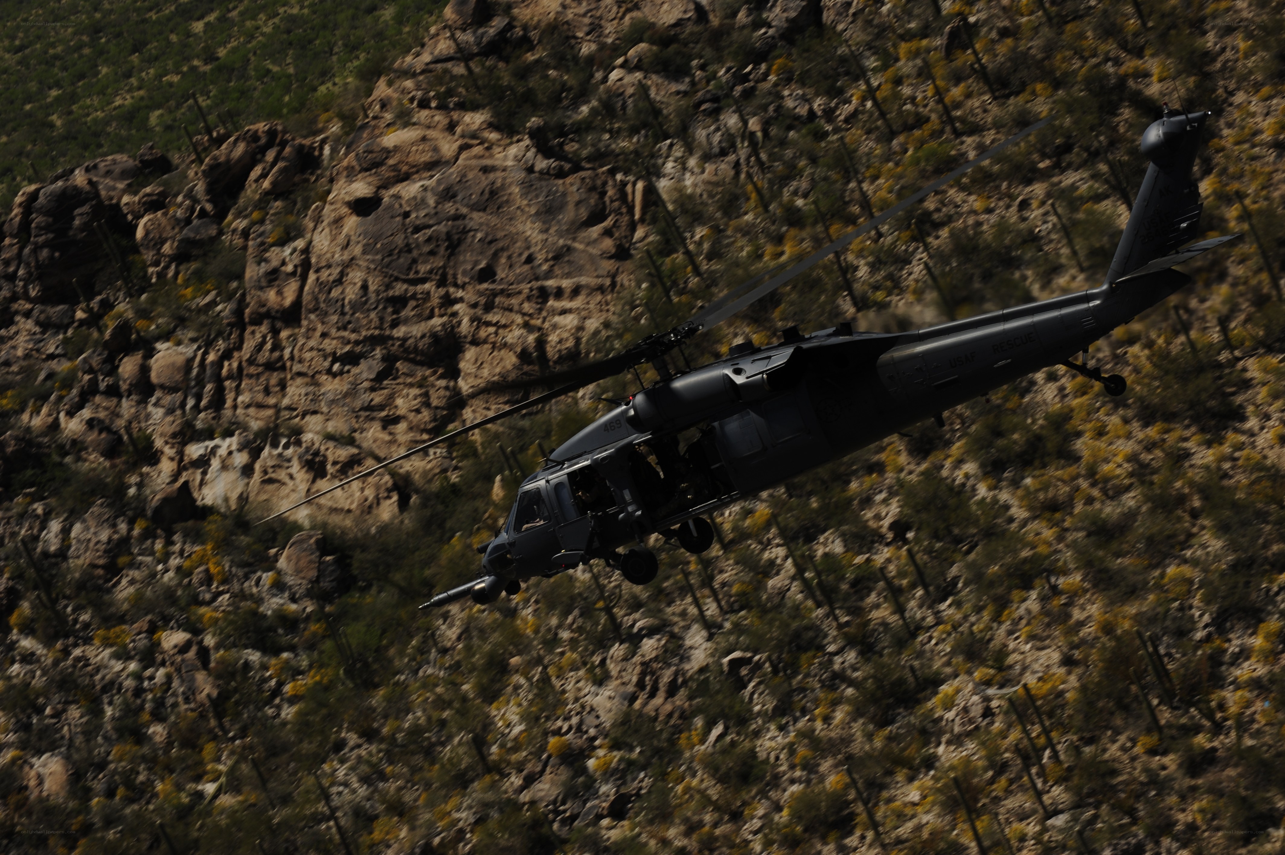 Military helicopter flying over canyon