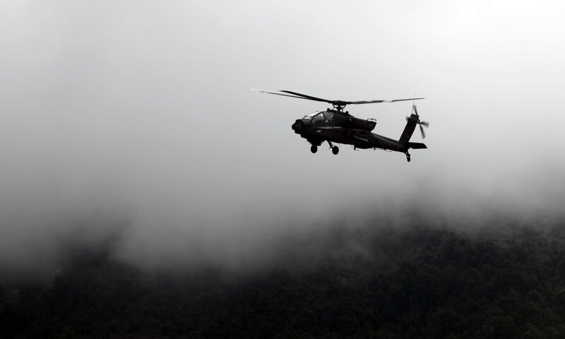Military helicopter flying over fog