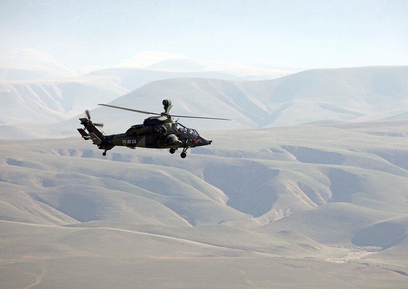Military helicopter flying over mountains