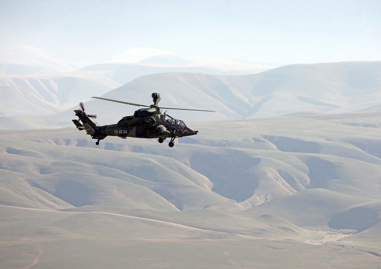 Military helicopter flying over mountains
