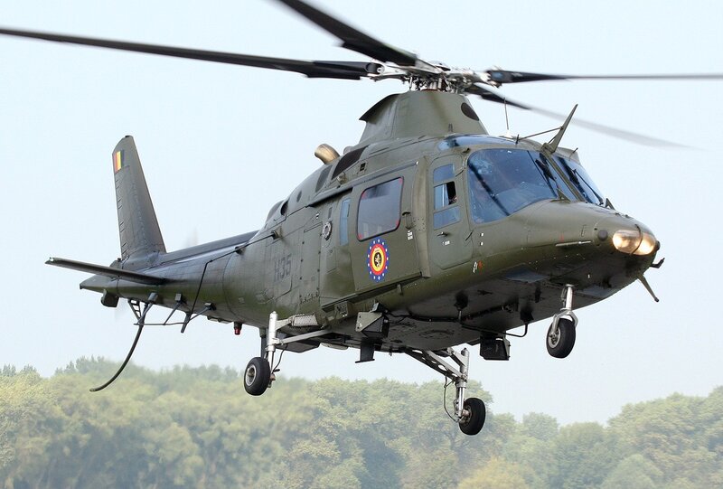 Military Helicopter in Flight — Green, Dynamic, Afternoon, Photograph, Forest, Sky, Landing Gear