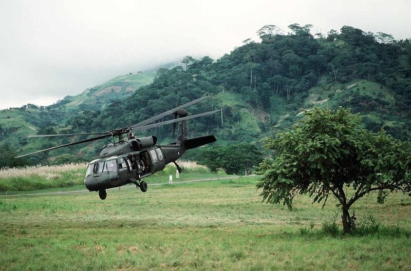 Military helicopter in grassy field