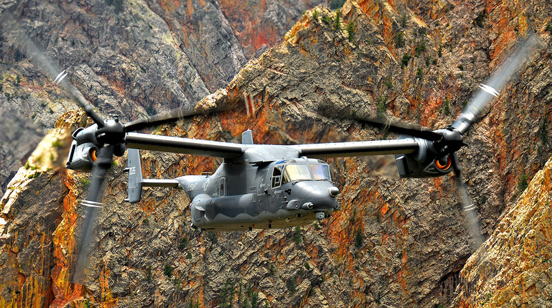 Military helicopter in mountain canyon