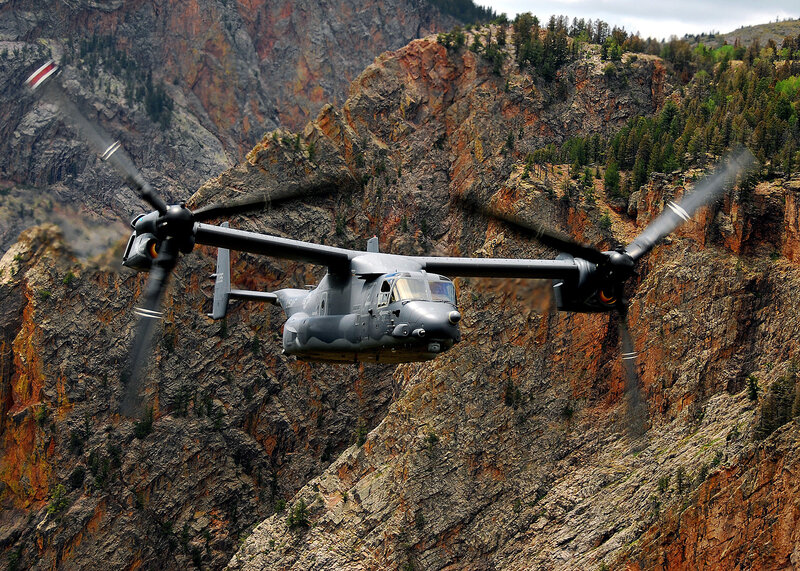 Military helicopter in mountain canyon