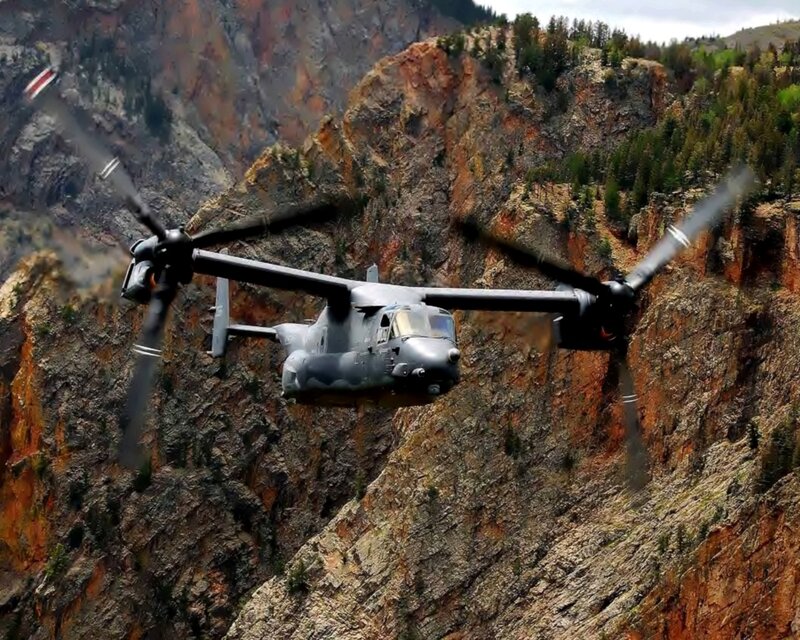 Military helicopter in mountain canyon