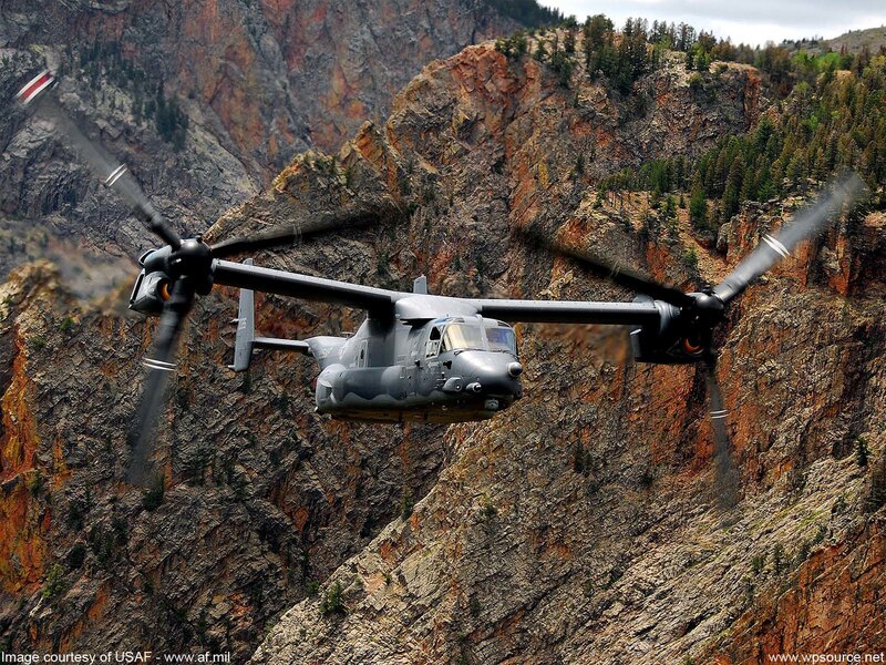 Military helicopter in mountain canyon