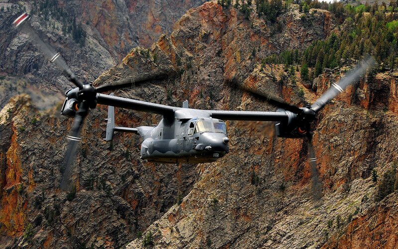 Military helicopter in mountain canyon