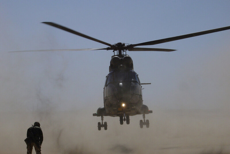 Military helicopter landing in desert
