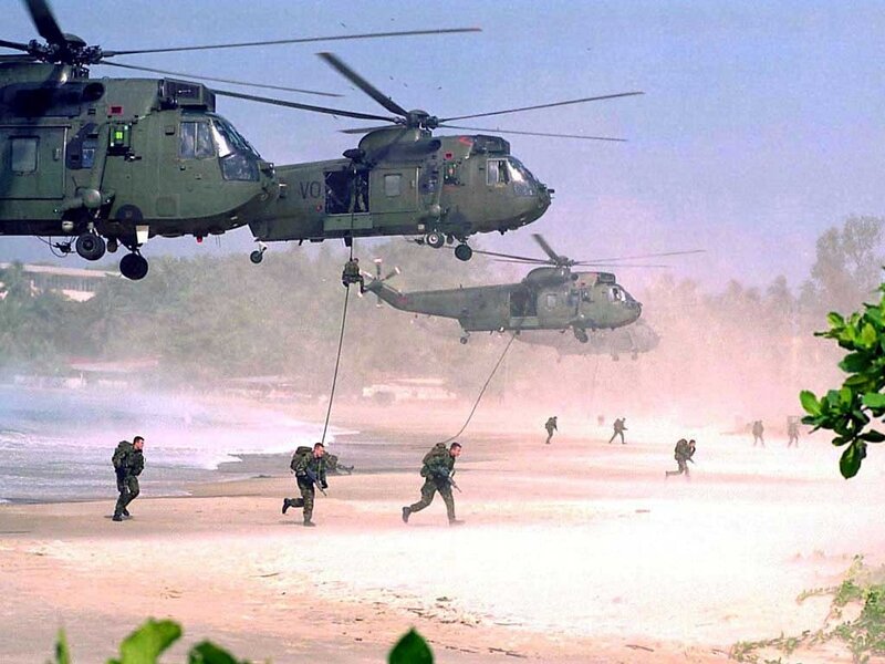 Military helicopter landing on beach