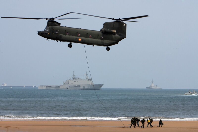 Military helicopter landing on beach