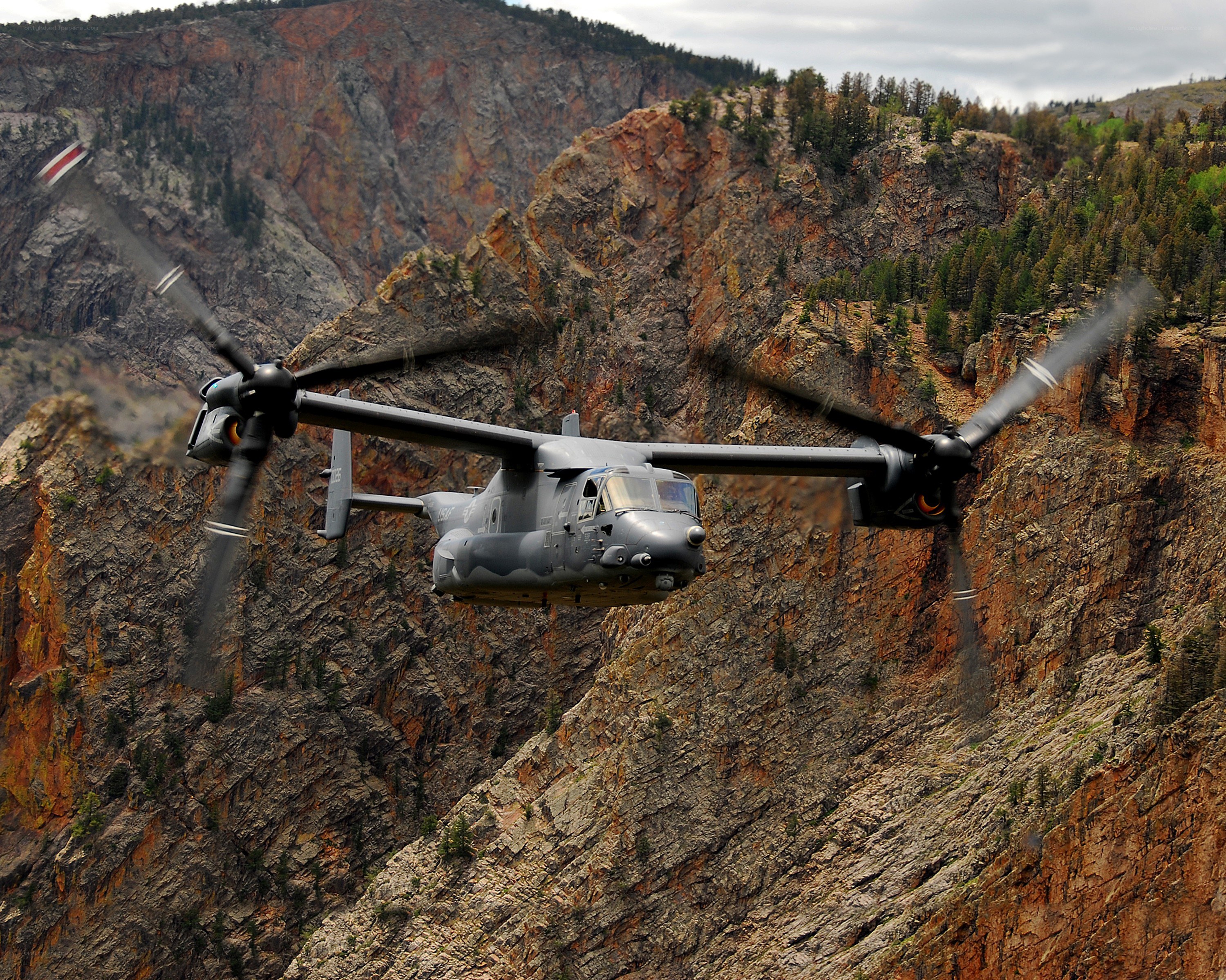 Military helicopter over canyon