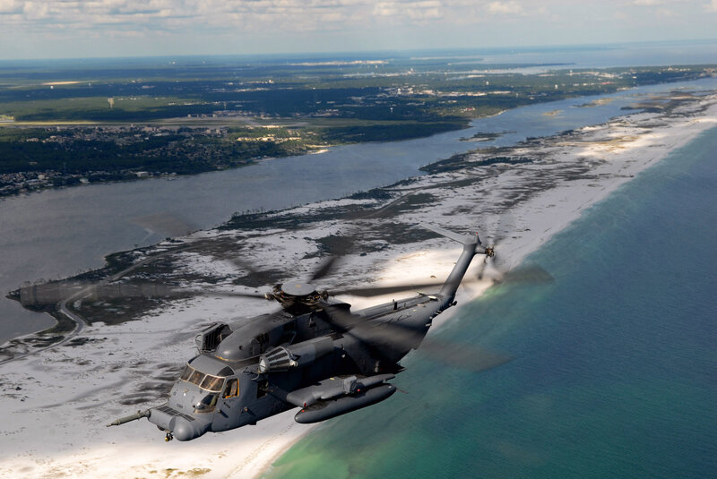 Military helicopter over coastal area