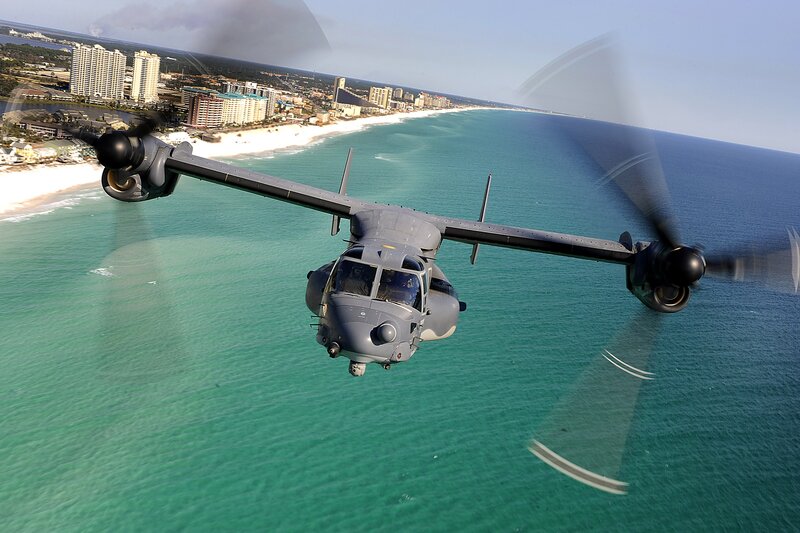 Military helicopter over coastal city