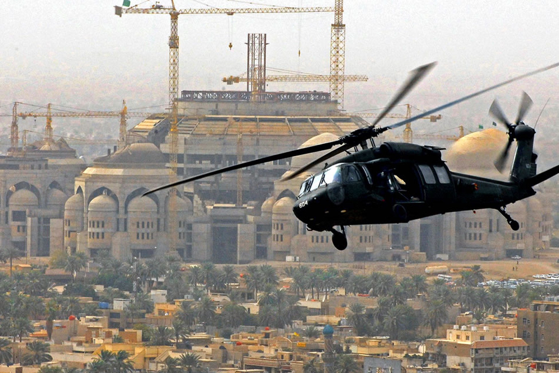Military helicopter over construction site