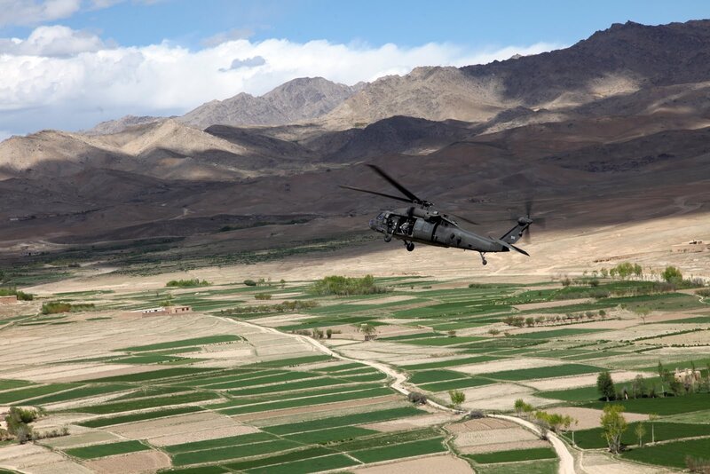 Military helicopter over farmland