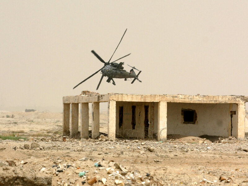Military helicopter over ruins