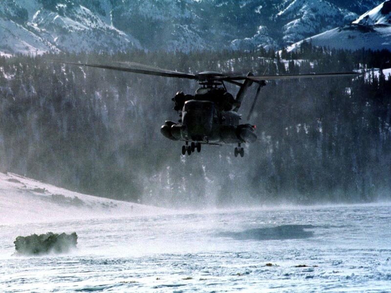 Military helicopter over snowy terrain