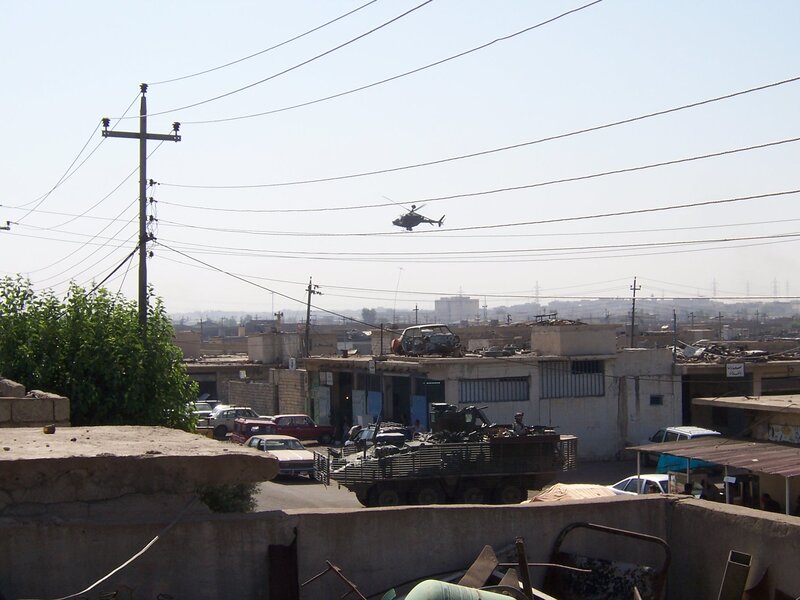 Military helicopter over urban area