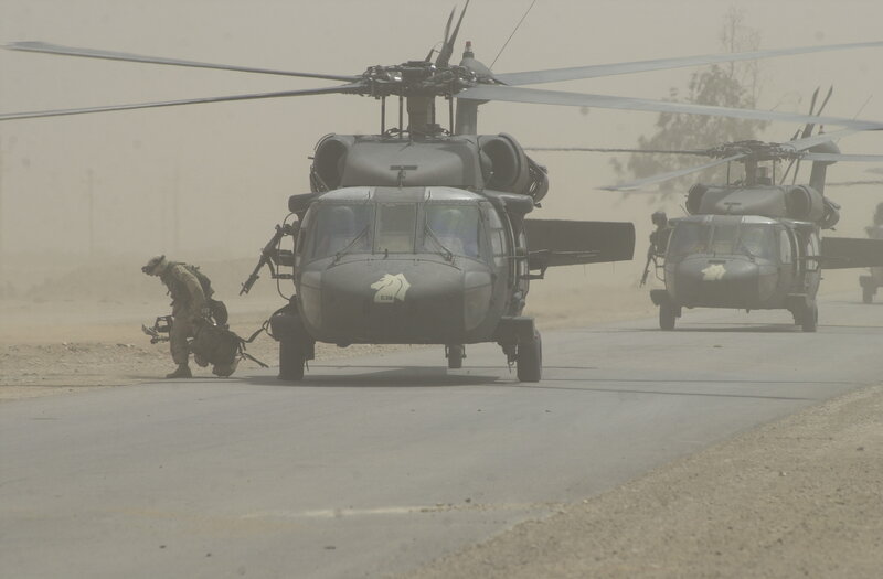 Military helicopters on a dusty airfield