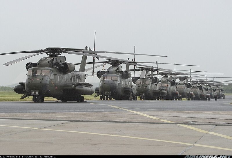 Military Helicopters on Tarmac — Gray, Serious