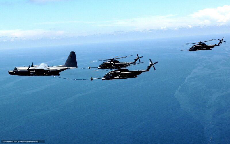 Military helicopters refueling over ocean