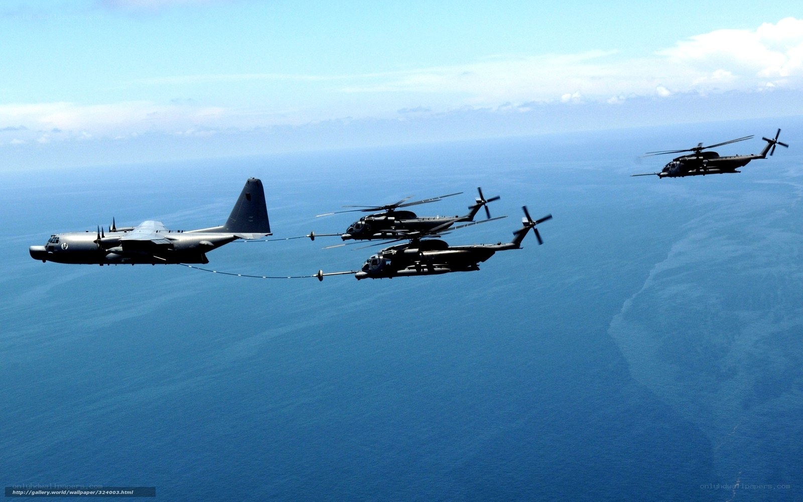 Military helicopters refueling over ocean