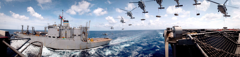 Military helicopters resupplying ship