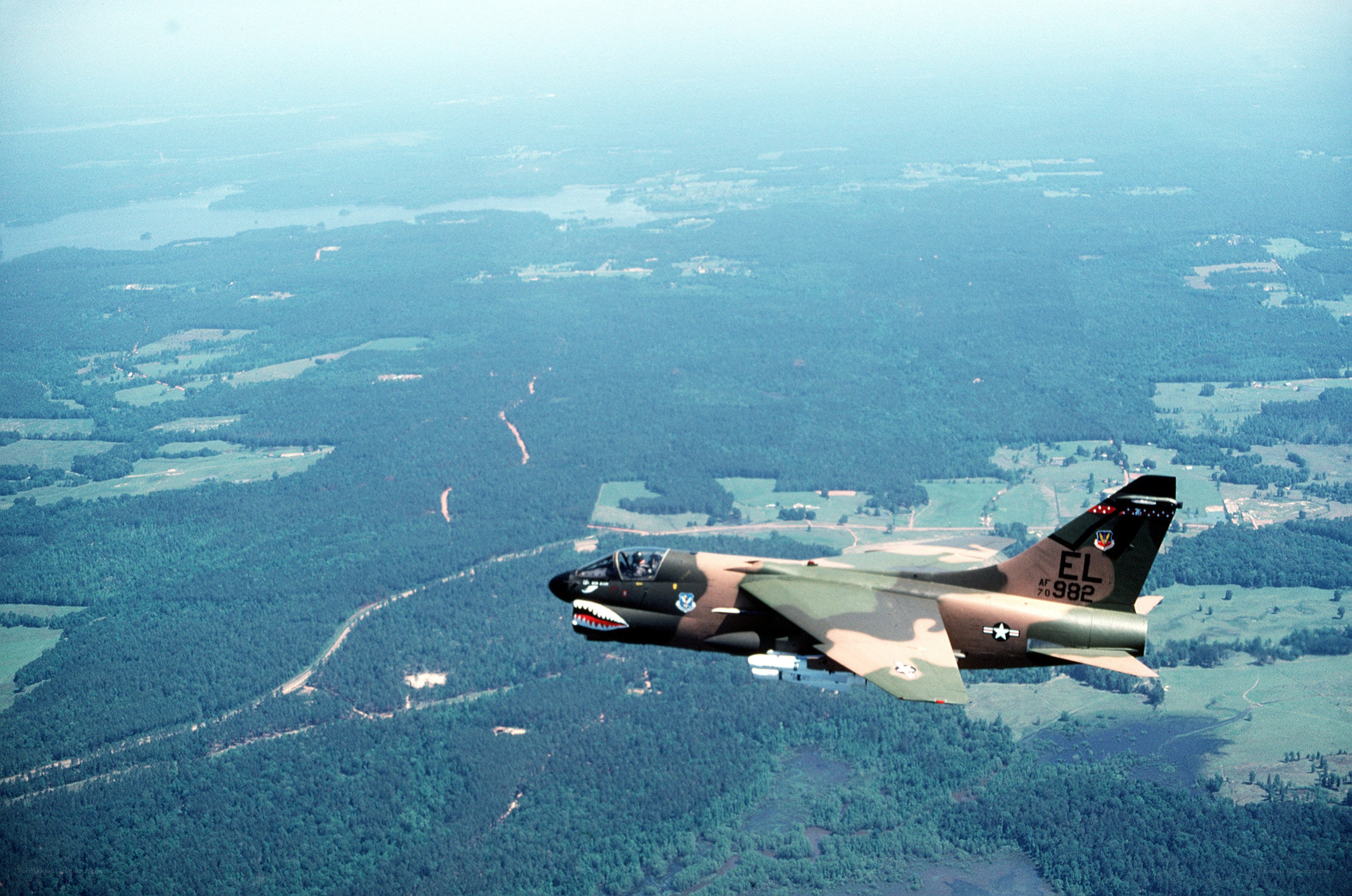 Military jet flying over forest