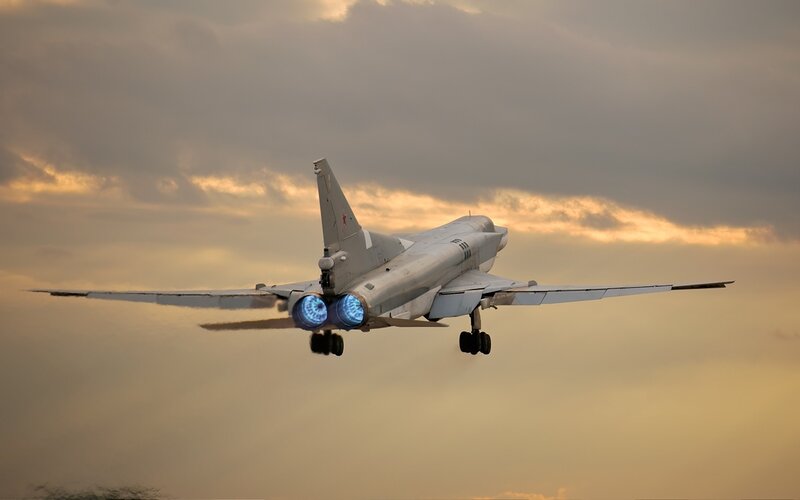 Military jet in flight at sunset