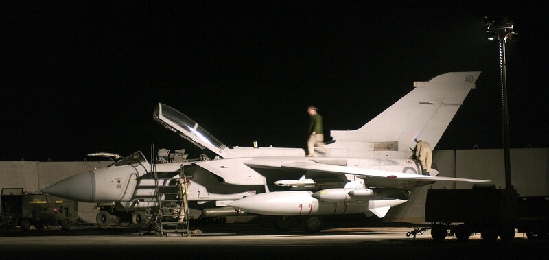 Military jet on tarmac at night