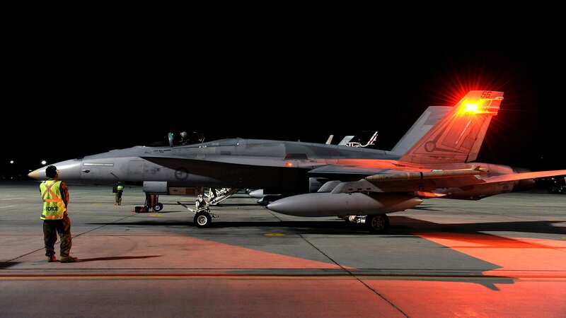 Military jet on tarmac at night