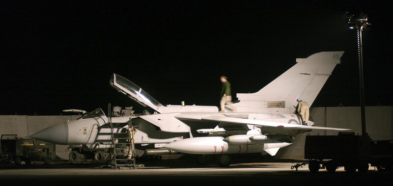 Military jet on tarmac at night
