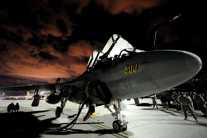 Military jet on tarmac at night