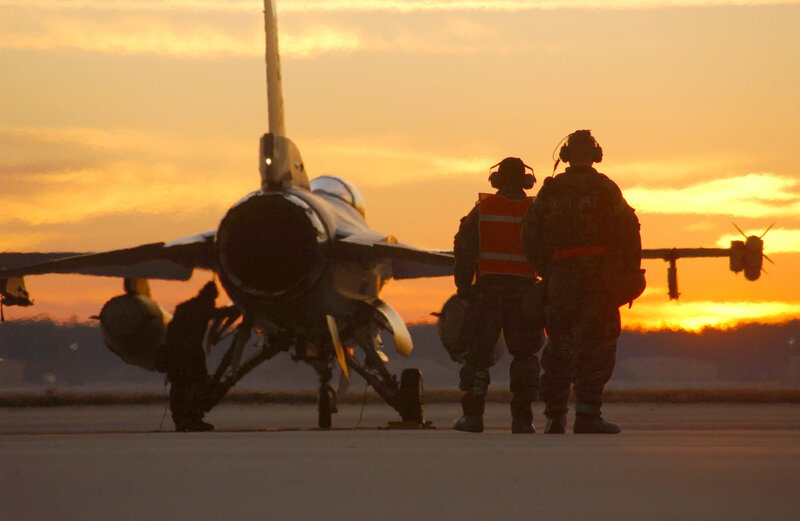 Military jet on tarmac at sunset