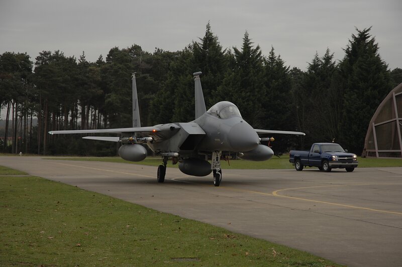 Military Jet on Tarmac — Gray, Overcast, Photograph, Truck