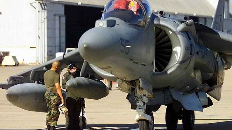 Military jet on tarmac with crew