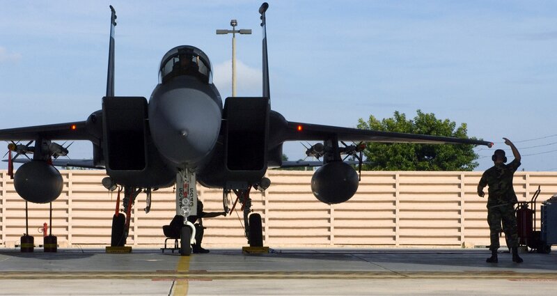 Military jet on tarmac with crew