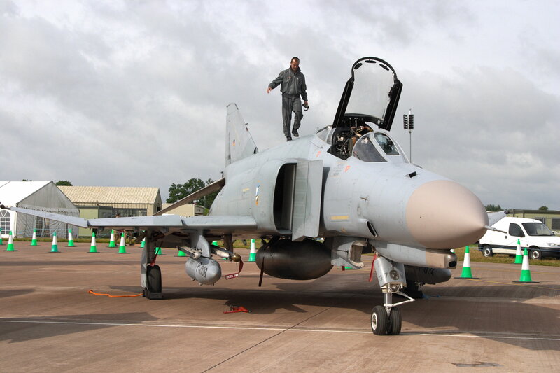 Military jet on tarmac with crew