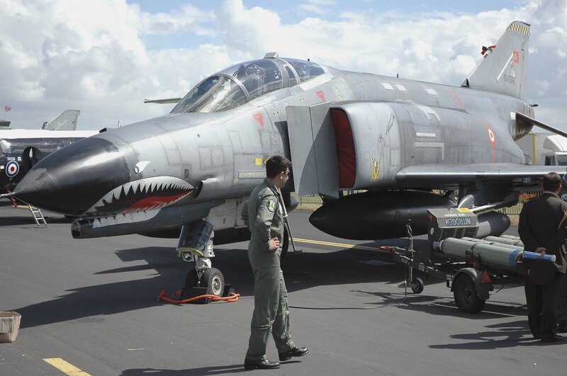Military jet on tarmac with pilot
