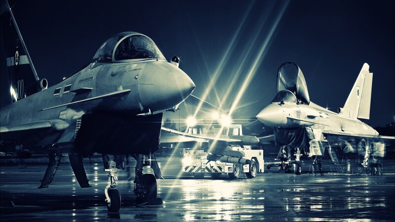 Military jets on tarmac at night