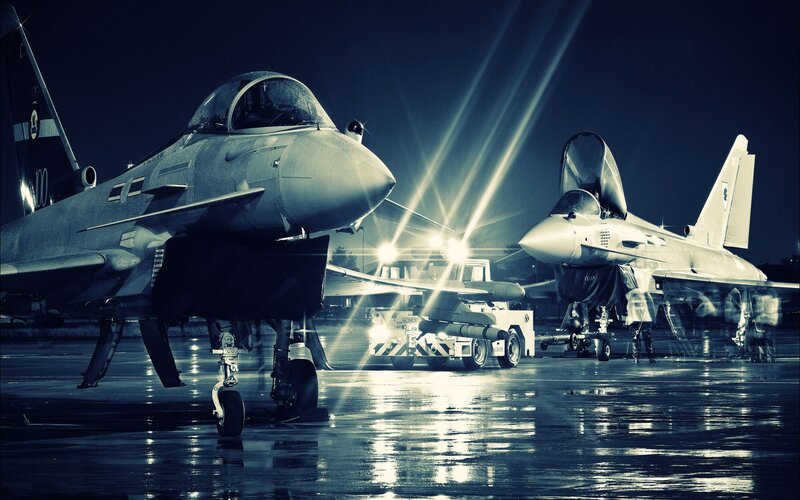 Military jets on tarmac at night