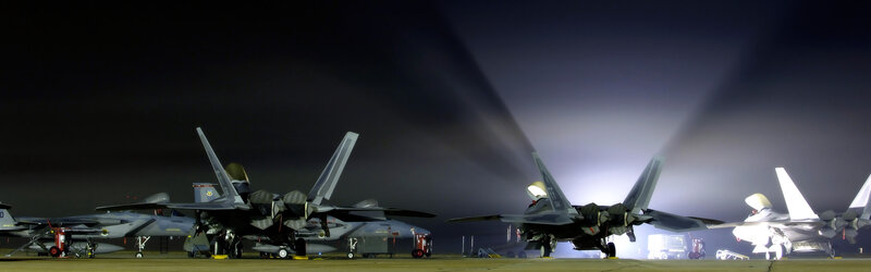Military jets on tarmac at night