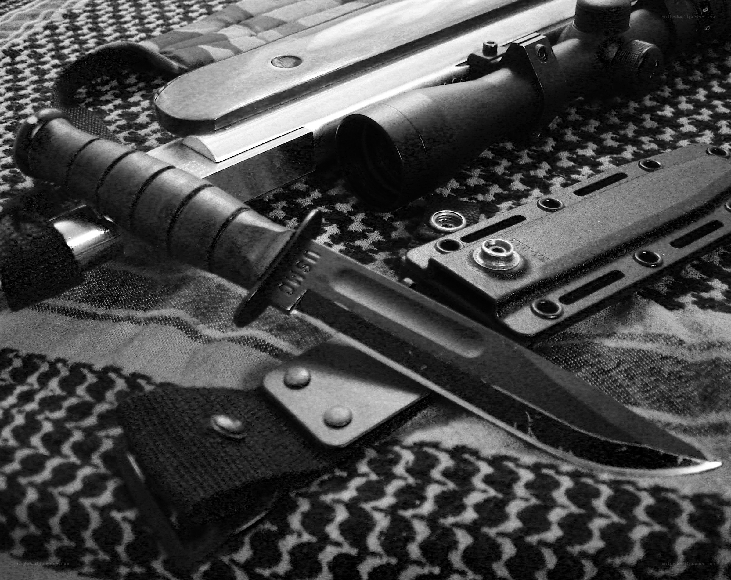 Military knife and scope on patterned cloth